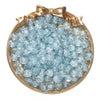 A round gold-rimmed dish filled with small, light blue glass crackle beads for jewelry making