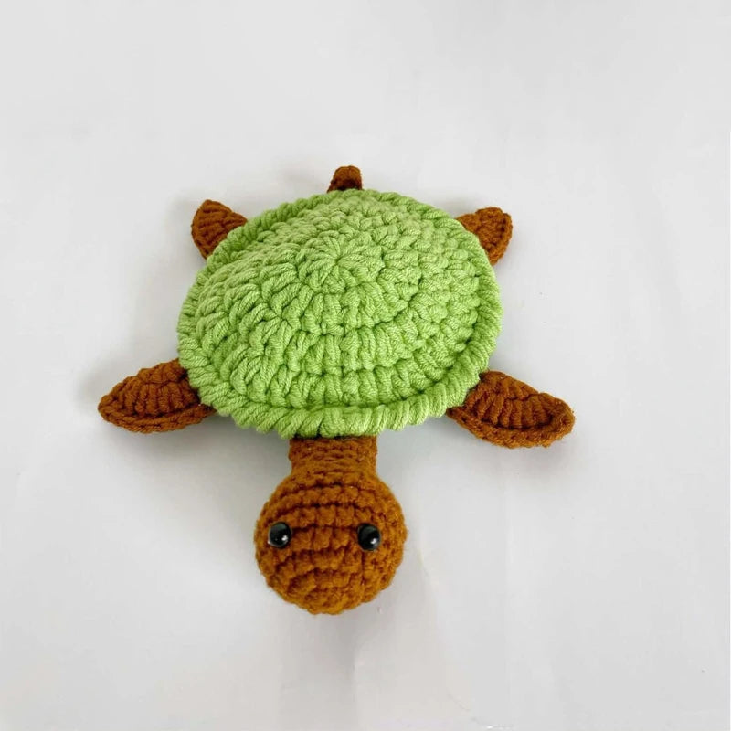 Handmade crochet lizard coaster featuring a green body and brown limbs