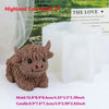 A brown silicone mold shaped like a Highland cow is displayed next to a white candle and text about The Love.
