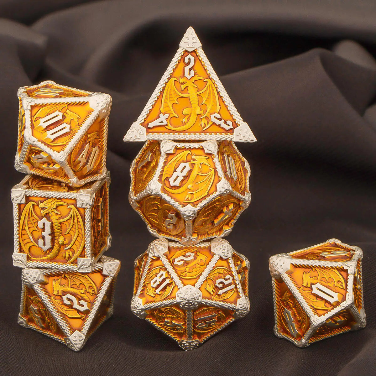 A set of seven polyhedral metal dice, including a pyramid and various polyhedrons, with gold and white accents.