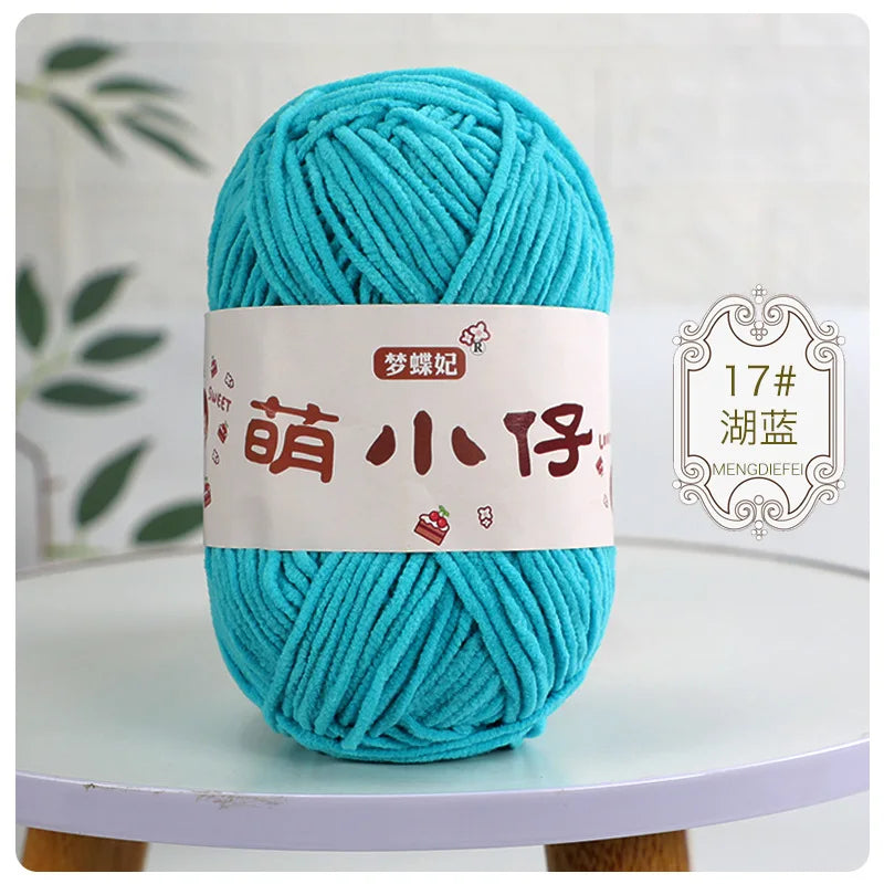 A skein of bright turquoise chenille yarn labeled with Chinese characters for knitting and crochet.