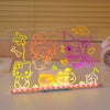 A glowing acrylic message board featuring seven colorful, neon-like drawings of cats and stars.
