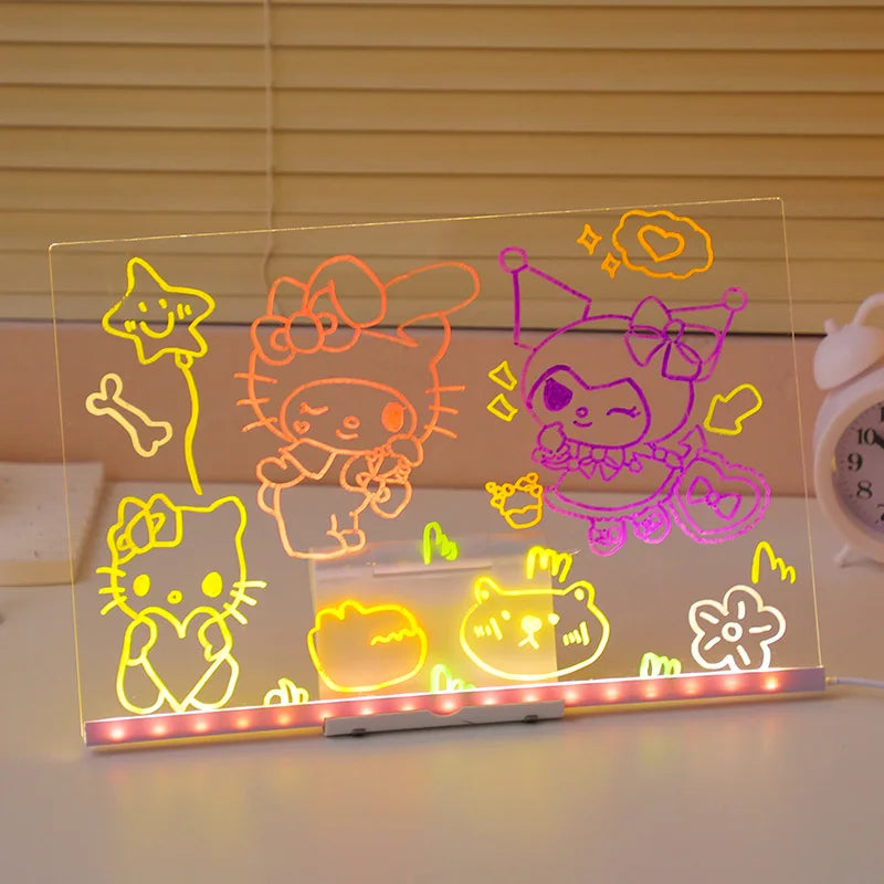 A glowing acrylic message board featuring seven colorful, neon-like drawings of cats and stars.