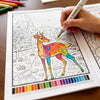 A hand is coloring a detailed deer illustration in a black and white line art coloring book.