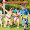 Three children playing outdoor games with pull-string flying saucer toys in a grassy park.