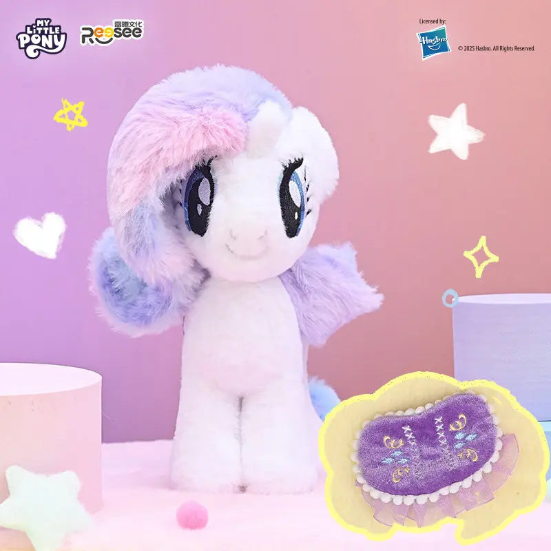 A fluffy white pony plush toy with purple and blue mane and tail, featuring a detachable saddle pendant.