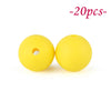 Two yellow silicone beads are shown against a white background.