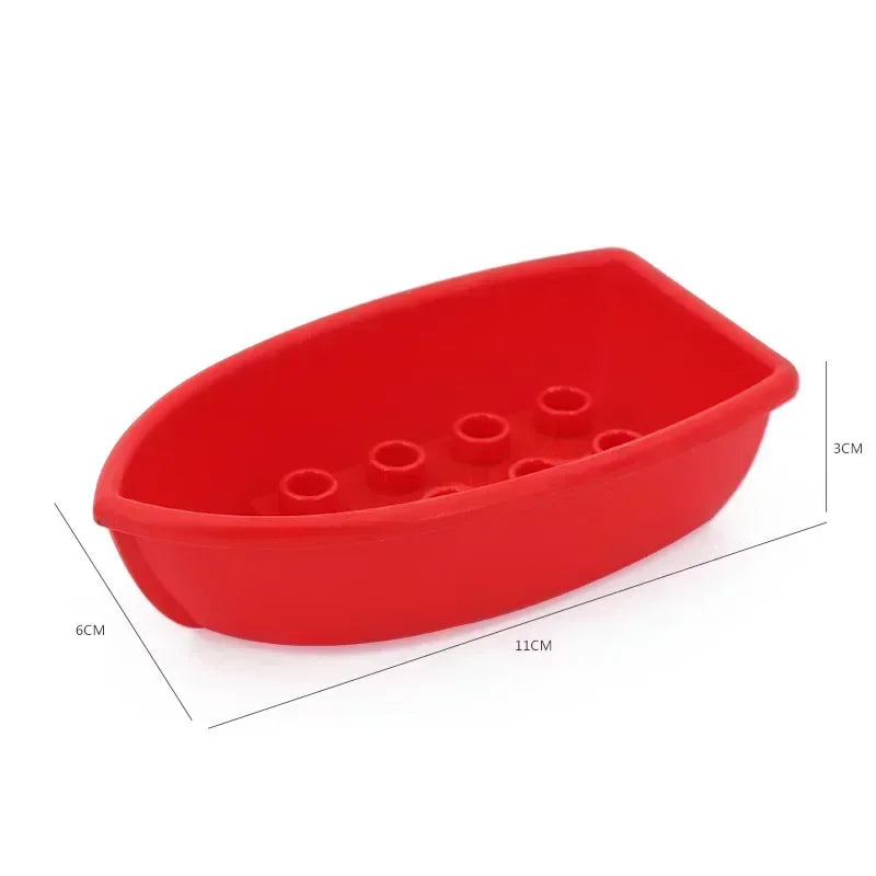 A red plastic building block tray with multiple holes for city traffic vehicles like trucks and buses.