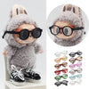 A fluffy gray rabbit doll wearing round black glasses and a knitted hat.