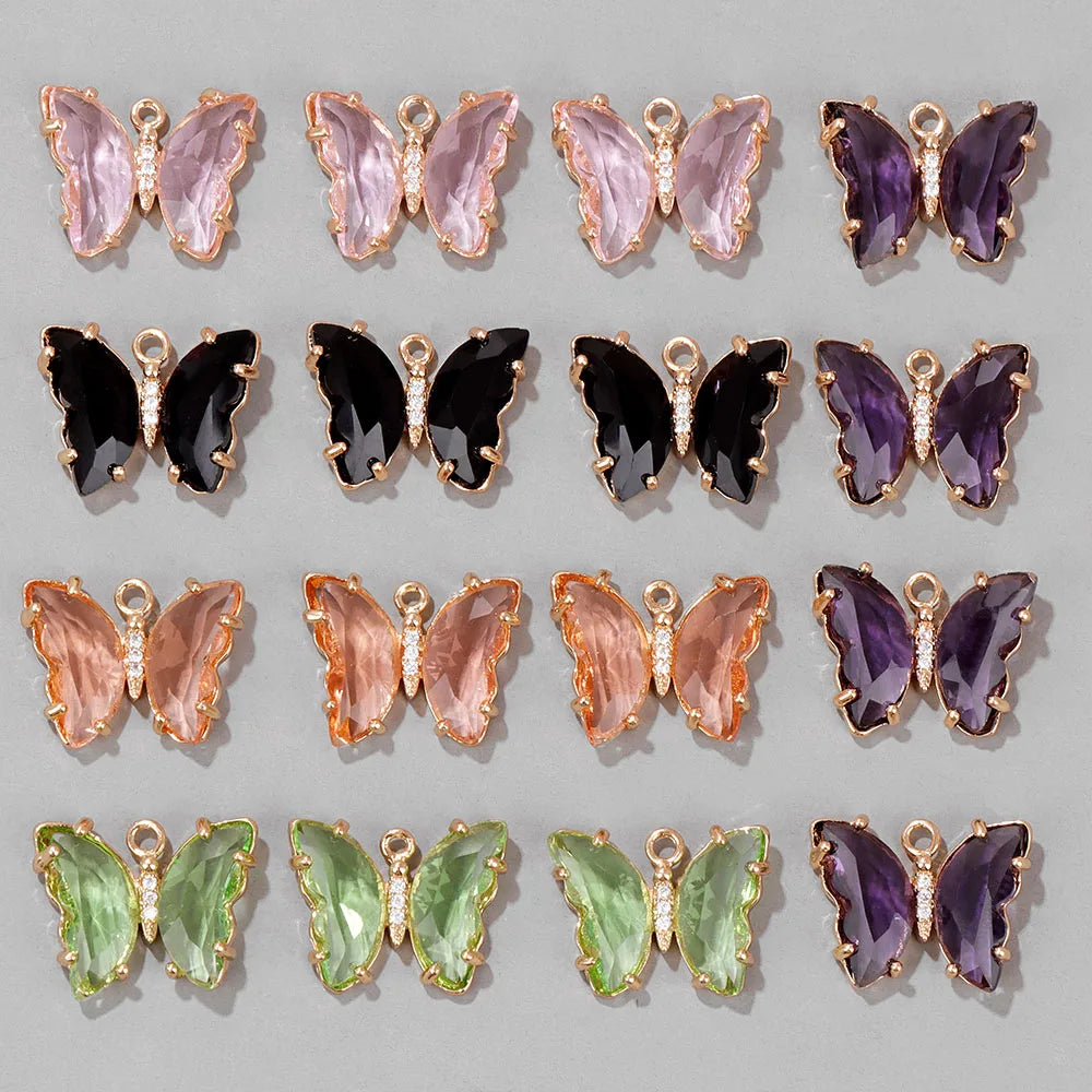 A collection of crystal butterfly charm beads in various shades of pink, purple, and green.