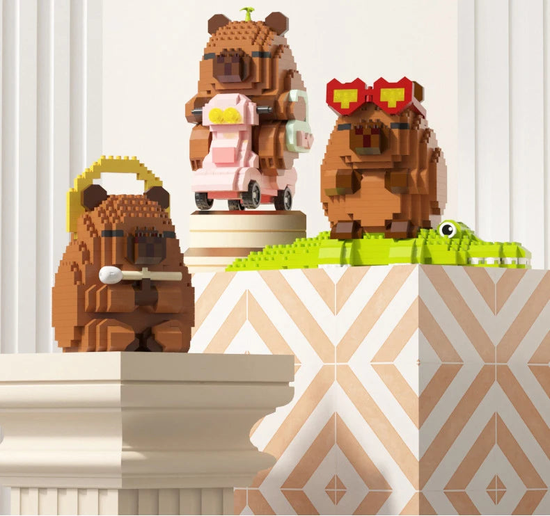 A set of cute capybara micro building blocks featuring a brown bear, a pink capybara, and a brown bear with red glasses.