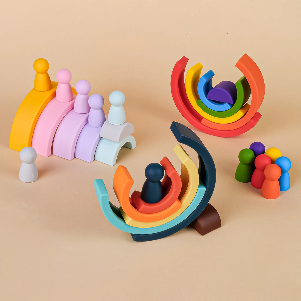 A collection of soft silicone rainbow building blocks in various colors and shapes, including stacked figures and swirling de