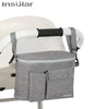 A gray Insular stroller organizer bag with a bottle holder is shown on a white baby stroller.