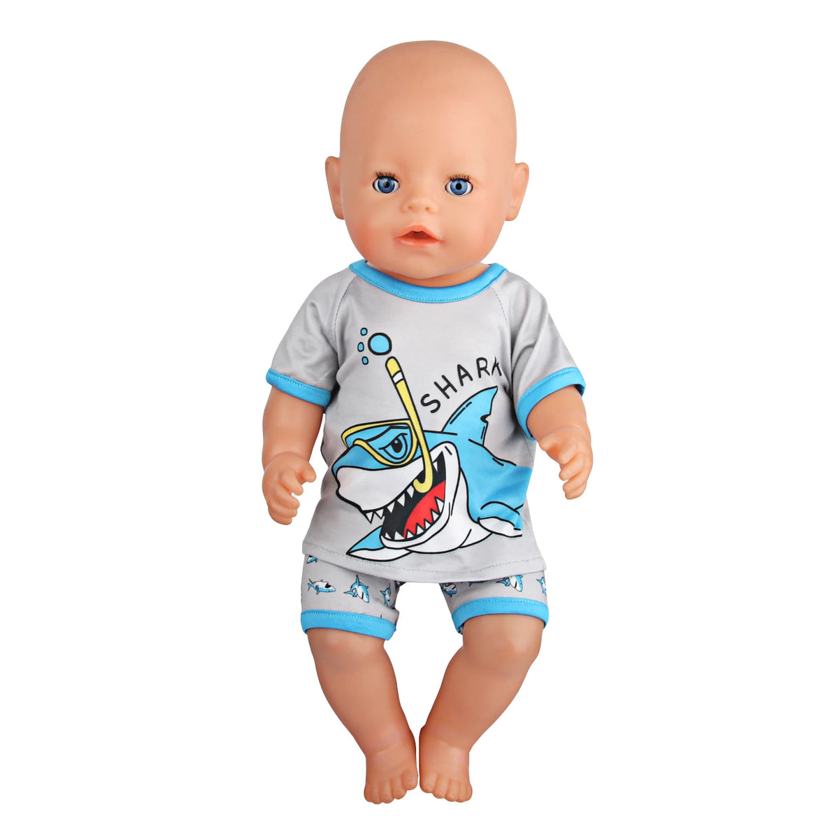 A baby doll wearing a gray shirt with a shark graphic and blue shorts.