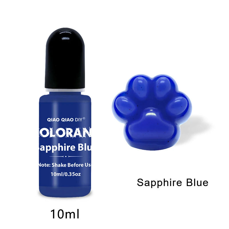 A small dark blue glass bottle of Oloran Sapphire Blue liquid dye with a black cap and a paw print shape on the label.