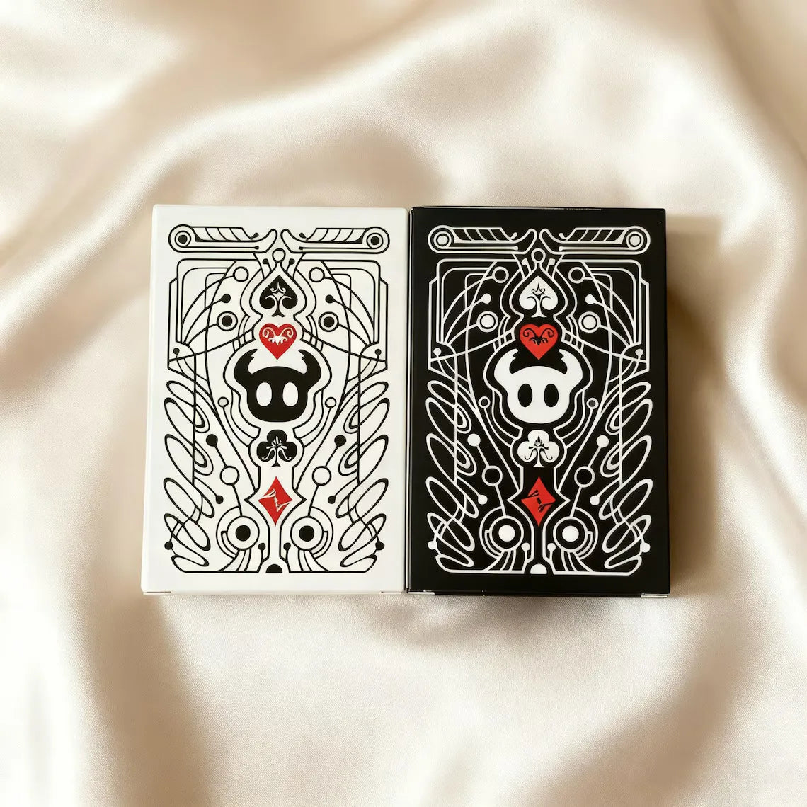 A black and white poker card deck featuring intricate line art designs on a square box.