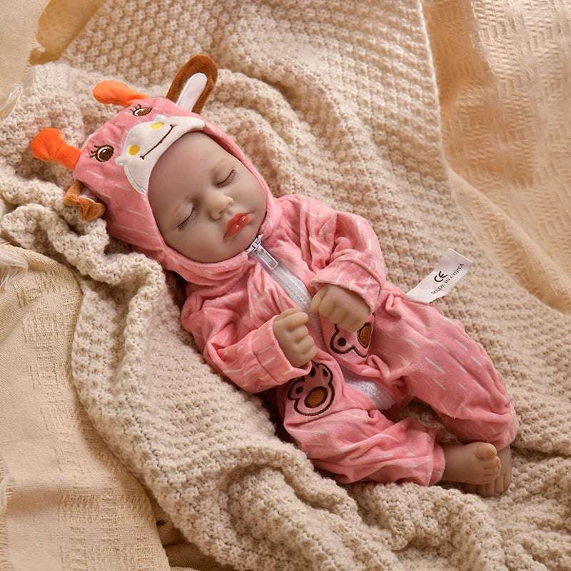 A pink animal romper set for a baby doll lying on a beige knitted fabric.