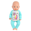 A baby doll wearing a light blue unicorn pajama set with a 'time to be unicorn' graphic.