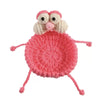A handmade crochet lizard with large eyes sitting on a pink circular coaster.