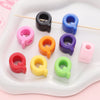A collection of colorful acrylic letter beads in pink, purple, orange, and green are displayed on a white tray with wooden st