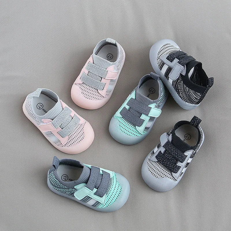A collection of five breathable mesh toddler walking shoes in pink, gray, and mint green tones.