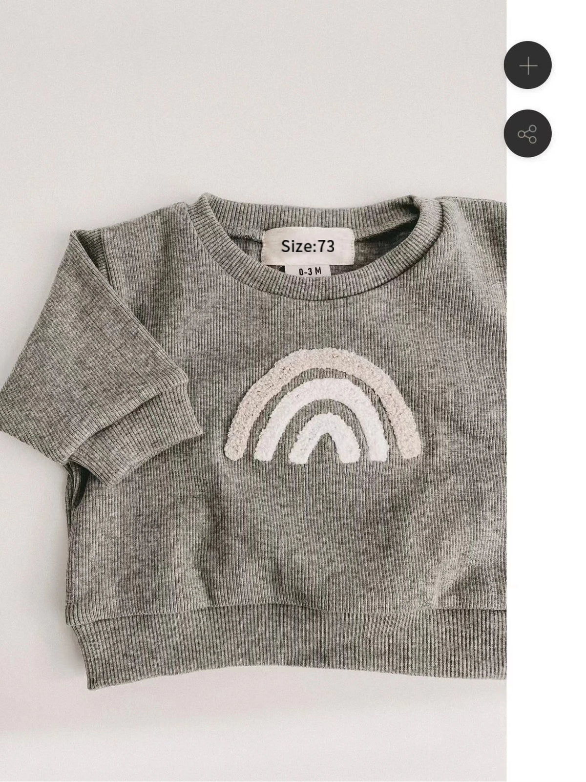 A gray long-sleeve top for a baby girl featuring a white rainbow graphic.