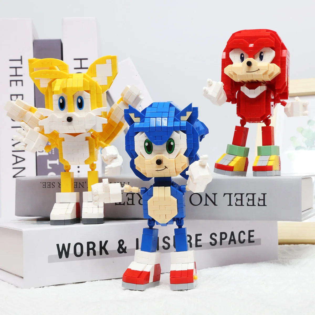 A set of three Sonic the Hedgehog figures in various colors and poses displayed on a white surface.