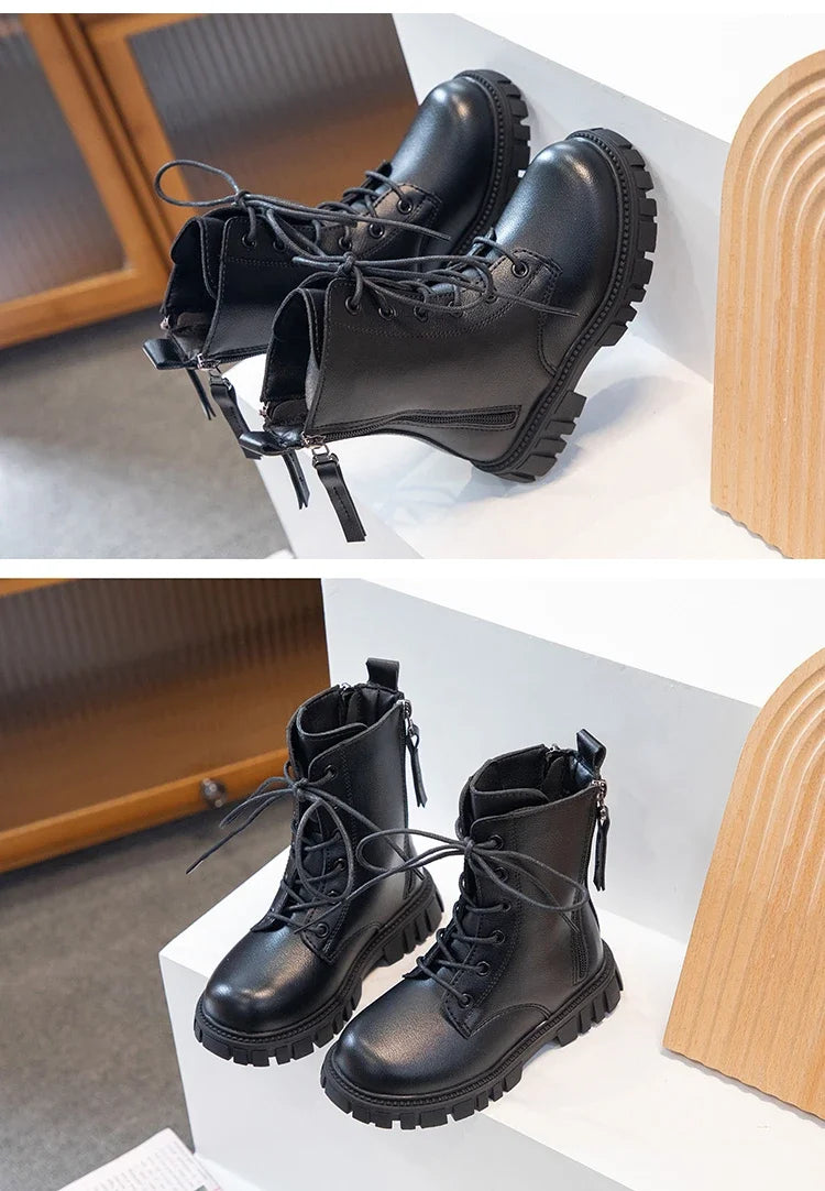 A pair of black girls' ankle boots with laces and anti-skid rubber soles displayed on a white surface.