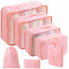 A set of pink travel packing cubes and a storage bag for organizing items.