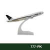 A white diecast model of a Boeing airplane with black markings and tail fin, displayed on a clear stand.