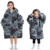 A girl models a gray and black fuzzy flannel hoodie sweater for kids.