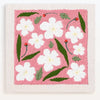 A pink punch needle embroidery featuring white flowers and green leaves.