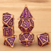A set of seven polyhedral metal dice, including a pyramid and dodecahedron shapes, with purple and gold accents.