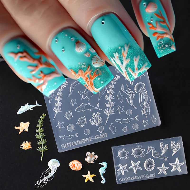 A hand displays various silicone nail art molds featuring orange and white coral, fish, and sea life designs on a clear backg