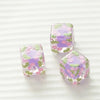 Three square floral resin beads in purple and green hues displayed on a white background.