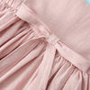A light pink linen jumper dress for a toddler girl with gathered fabric details.