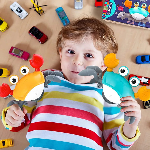 A young boy holds an interactive dancing crab pet toy with orange and gray parts against a light wooden background.
