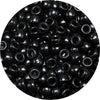 A close-up view of small, black pony beads scattered across a dark surface.