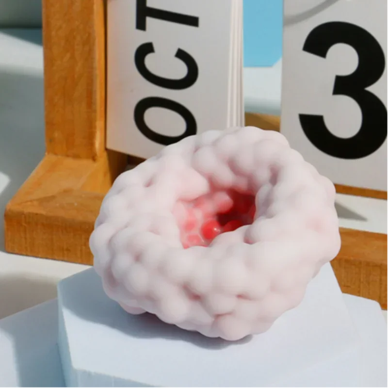 A pink, squishy stress relief ball with a red center is displayed next to a calendar showing October 3rd.