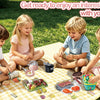 Children playing outdoors on a picnic blanket with pretend play food and cookware.