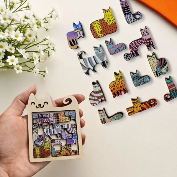 A hand holds a wooden cat-shaped puzzle featuring various colorful, patterned cats.