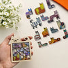 A hand holds a wooden cat-shaped puzzle featuring various colorful, patterned cats.