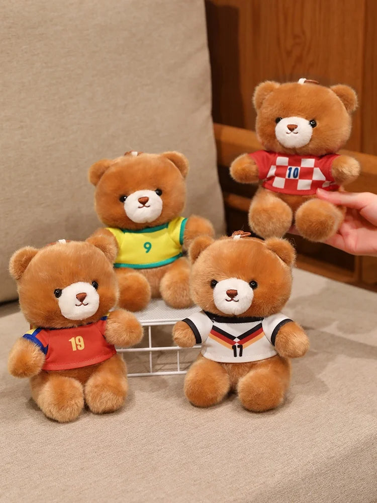 Three teddy bears wearing football jerseys, including one with a yellow jersey and two others in red and white.