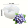 Moule en silicone blanc de 6 cm de diamètre et 2,5 cm de hauteur, à côté d'un bouquet de fleurs violettes.