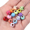 A collection of colorful rhinestone acrylic spacer beads in various shades of pink, green, yellow, and purple are displayed o