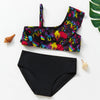 A black two-piece swimsuit set with colorful text print laid out on a white surface.