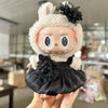 A small doll wearing a wedding dress outfit set with fluffy white fur and black accents.