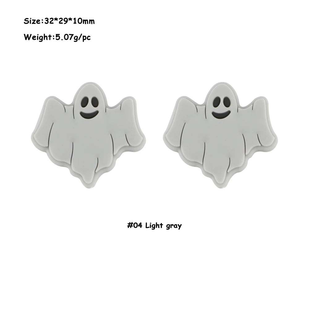 A pair of light gray silicone ghost-shaped beads for jewelry making.