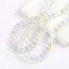 Clear glass star spacer beads arranged in two strands on a white surface for jewelry making