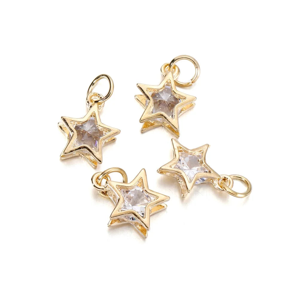 Three gold-toned star charms with clear rhinestones and jump rings for jewelry making